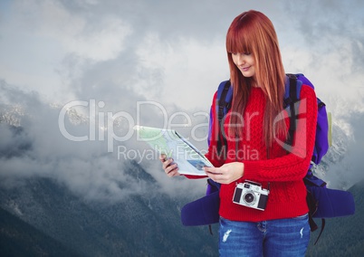 Millennial backpacker with map against snowy mountains