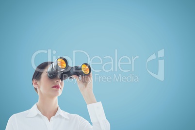 Woman looking through binoculars against blue background and copy space