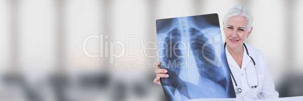 Doctor with x-ray against white blurred background