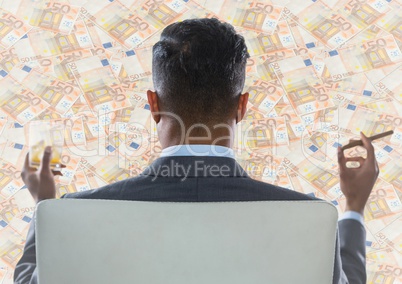 Back of business man in chair looking at money backdrop