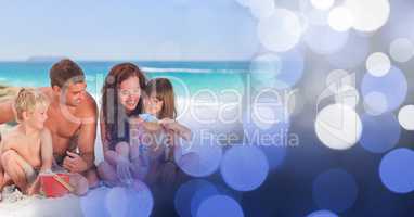 Family at beach with bucket and spade with blue bokeh transition