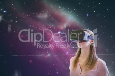 Woman in VR headset looking against pink galaxy background