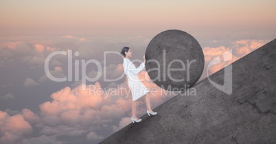 Woman pushing rolling round rock