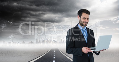 businessman on laptop in cityscape