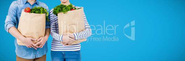 Shoppers mid sections with grocery bags against blue background and copy space