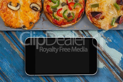 Phone on blue wooden desk with food and copy space