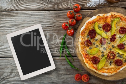 Tablet on wooden desk with food and copy space on tablet