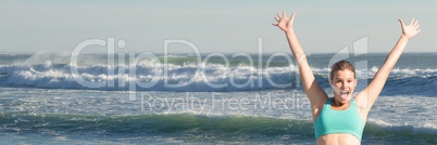 Woman in sports bra celebrating against waves