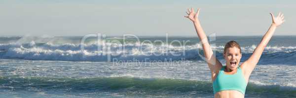 Woman in sports bra celebrating against waves