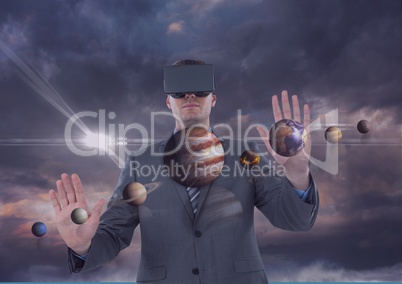 Man in VR headset touching 3D planets against purple sky with clouds and flares