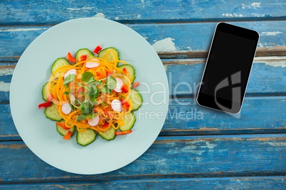 Phone on blue wooden desk with food and copy space on mobile phone