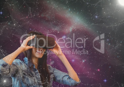 Happy woman in VR headset looking to a pink galaxy background