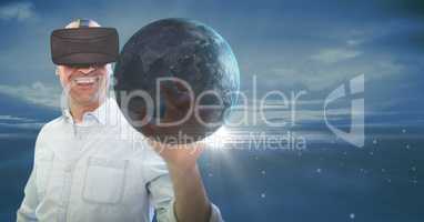 Happy man in VR touching 3D planet with flares against blue sky