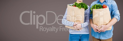 Couples mid sections with grocery bags against brown background 3d