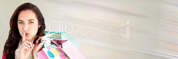 Shopper with bags and finger on mouth against cream motion blur and copy space