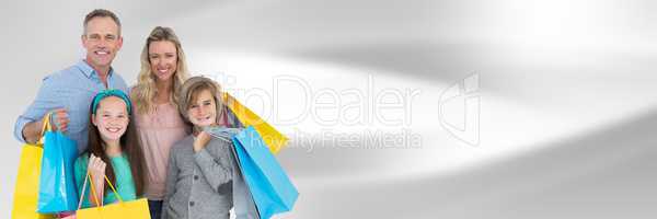 Family with shopping bags against blurry grey abstract background