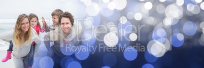 Family at beach doing piggy back with blue bokeh transition