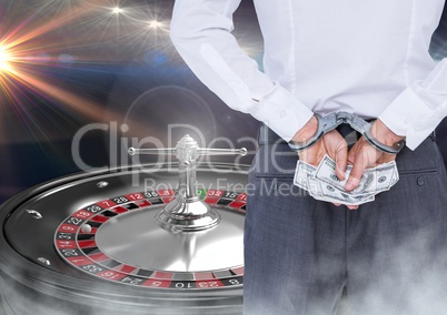 Man in hand cuffs with money and 3d roulette machine