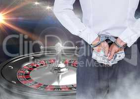 Man in hand cuffs with money and 3d roulette machine