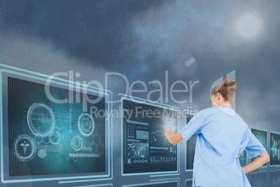 Woman doctor interacting with 3d medical interfaces against blue background with flares