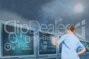 Woman doctor interacting with 3d medical interfaces against blue background with flares