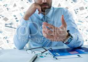 Business man with glass tablet at desk against documents backdrop