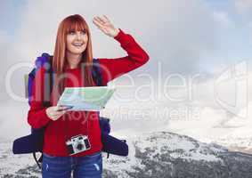 Millennial backpacker with map against snowy mountains and sky