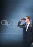 Man looking through binoculars against blue copy space wall