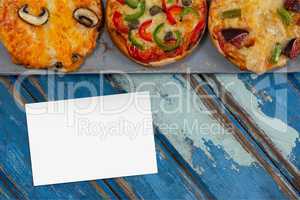 Bussiness card on blue wooden desk with food and copy space on a card