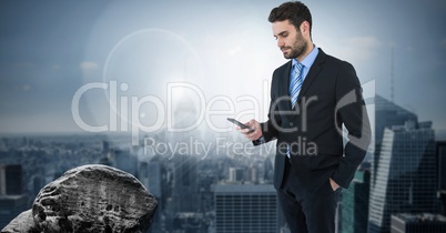 Dark sky with businessman holding phone over city Dark sky with businessman holding phone over city