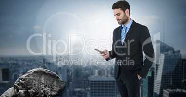 Dark sky with businessman holding phone over city