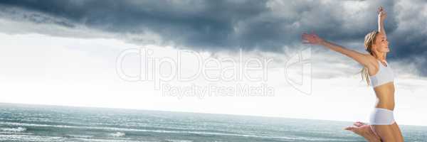 Woman in underwear celebrating on grey beach