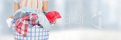 Cleaner holding laundry basket with bright background Cleaner holding laundry basket with bright background
