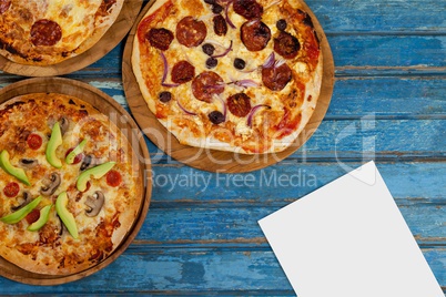 Blank card on blue wooden desk with food and copy space on paper