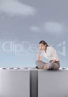 Woman sitting on a 3d maze against a sky with clouds