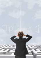 Confused woman looking at a maze against a sky with clouds