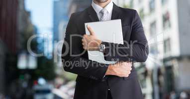 city with businessman holding laptop