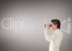Man looking through binoculars against brown background and copy space