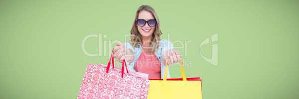 Shopper holding out bags against green background