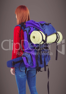 Back of millennial backpacker against brown background