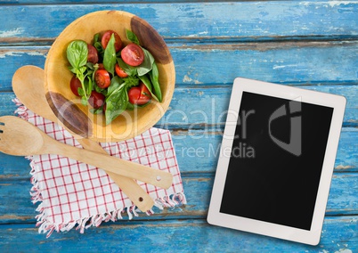 Tablet on blue wooden desk with food 3d