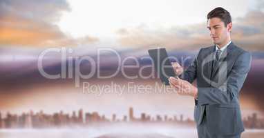 businessman with tablet in cityscape