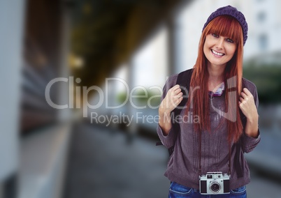 Millennial backpacker smiling against blurry station