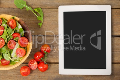 Tablet on wooden desk with food 3d