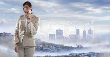 businesswoman with magnifying glass in cityscape