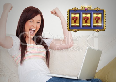 Casino slot machine 7's in front of woman celebrating playing on laptop computer