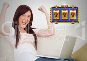 Casino slot machine 7's in front of woman celebrating playing on laptop computer