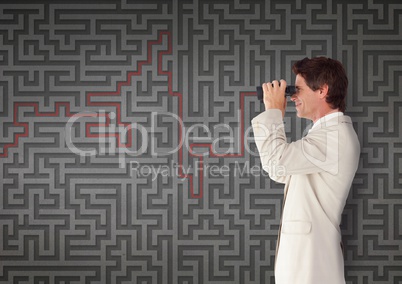 Man looking through binoculars against 3d maze background