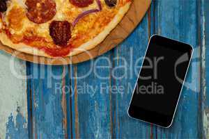 Phone on blue wooden desk with food and copy space on mobile phone