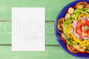 Blank card on green wooden desk with food and copy space on paper